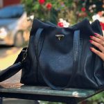 A model showing black color tote bag for ladies on table
